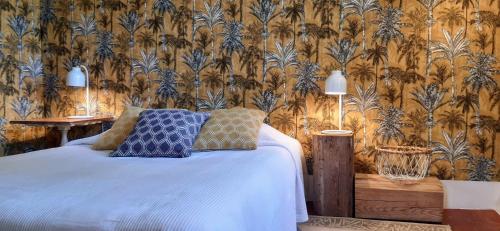 PuimoissonDomaine Saint Bonnet的一间卧室配有一张带蓝色枕头和壁纸的床