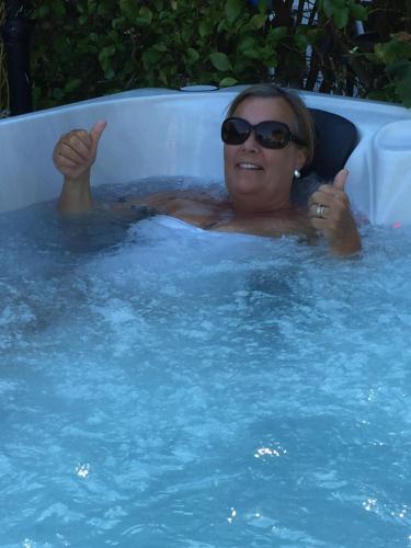 EvertonAnnexe in lymington with private use of hot tub的戴太阳镜的游泳池里的女人