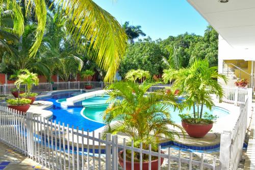 巴耶杜帕尔Hotel Campestre Villa Ocha的棕榈树和白色围栏的度假游泳池
