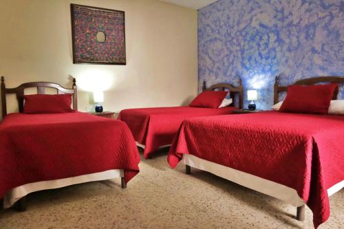 危地马拉安地瓜Hotel Posada San Miguel的红色床罩的房间里设有两张床