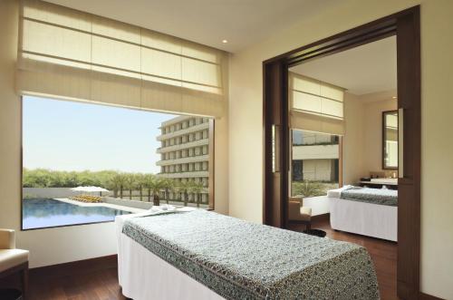 古尔冈古尔冈奥博罗伊酒店的一间卧室设有两张床和大窗户