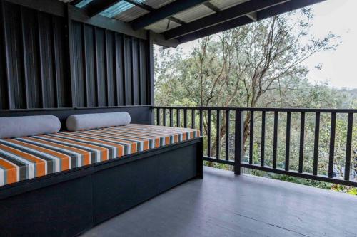 WarrandyteResort-style 4 bdrm home w pool, spa & billiards!的阳台设有1个带长凳的门廊,享有风景。