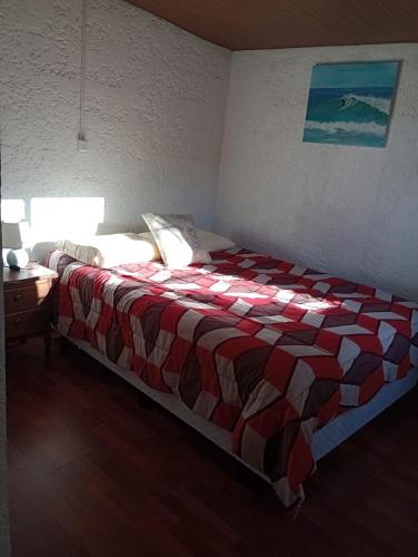 拉帕洛马Tákate DoS的一间卧室配有一张带红白毯子的床