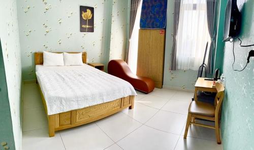 Bạc LiêuKhách Sạn HOÀNG KIM的一间卧室配有一张床和一把椅子