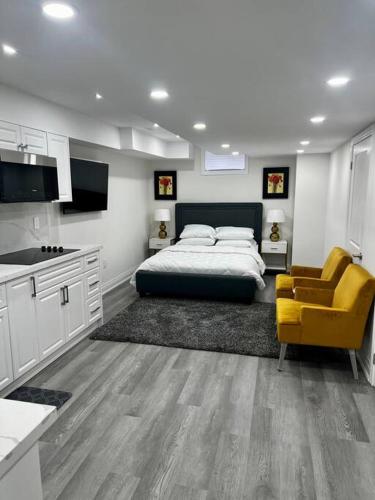 布兰普顿New Luxurious Studio Apartment的一间卧室配有一张床和一张黄色椅子