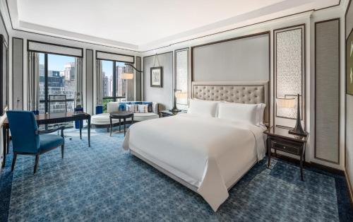 曼谷曼谷雅典娜豪华精选酒店 （万豪酒店）的卧室配有一张白色大床和一张书桌