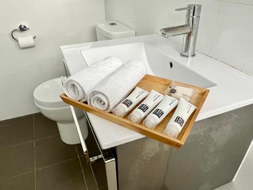 悉尼Charming One-Bed Apt in the Heart of Parramatta的浴室配有带毛巾的盥洗盆和卫生间。