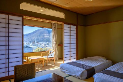 笛吹市Isawa Tokiwa Hotel的客房设有两张床和一个美景窗户。