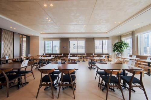 首尔首尔格拉斯丽酒店的用餐室设有桌椅和窗户。