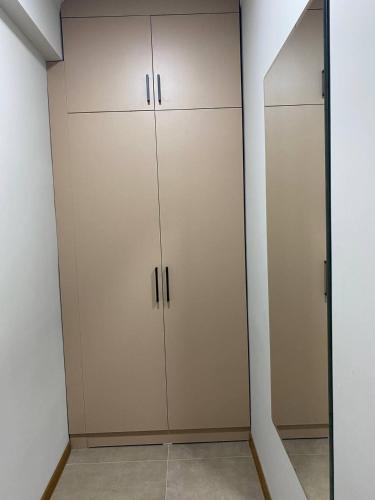 阿拉木图Уютная квартира-студия ЖК Теремки的衣柜配有白色橱柜和镜子