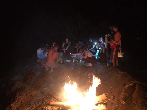 邦隆FamilyHouse & Trekking的一群人晚上坐在 ⁇ 火旁