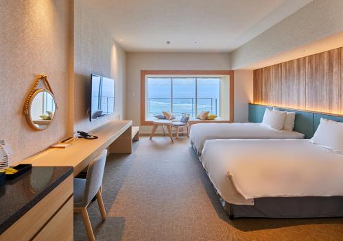 MinatogawaHOTEL AlaCOOJU OKINAWA的酒店客房配有两张床和一张书桌