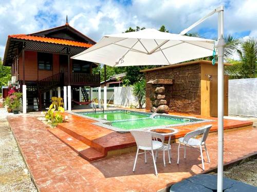 瓜拉丁加奴Inap Nekmi Kuala Terengganu With Pool的一个带桌子和遮阳伞的庭院和一个游泳池