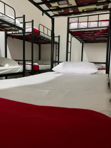 茂物Yayah Hostel的一间卧室配有三张双层床,铺有白色床单
