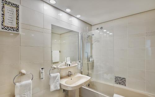 马德里Sercotel Togumar的一间带水槽、淋浴和镜子的浴室