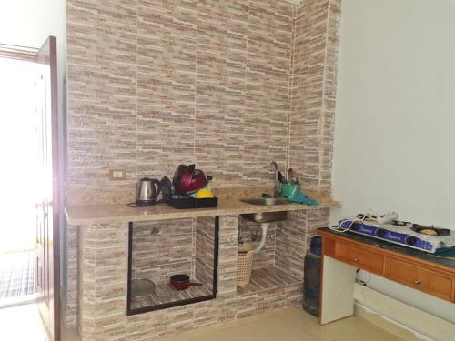 沙姆沙伊赫basic 2 bedroom apartment的厨房设有柜台和砖墙