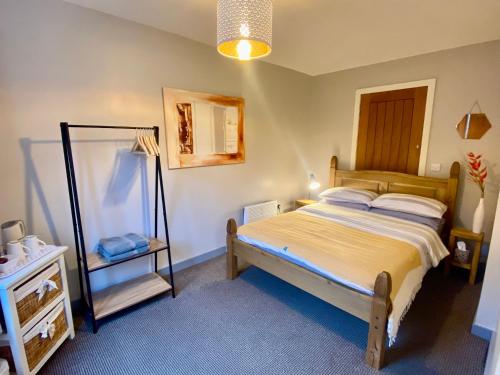 Inversnaid因弗斯内德旅舍的一间小卧室,配有一张床和镜子