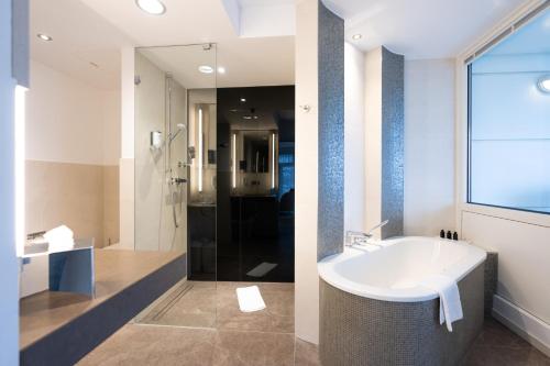 波茨坦Kongresshotel Potsdam am Templiner See的浴室配有白色水槽和淋浴。