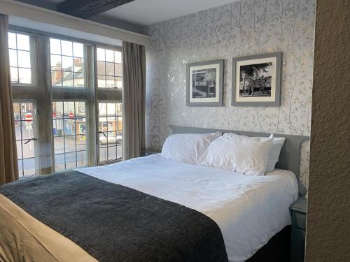班伯里Cromwell Lodge Hotel by Greene King Inns的一间卧室配有一张带白色床单的床和一扇窗户。