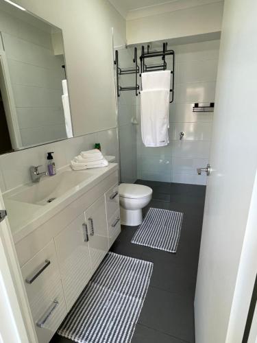 莫宁顿Private guesthouse - Minutes from the beach!的一间带水槽、卫生间和镜子的浴室