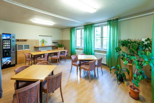舍讷费尔德施瓦尔本维格潘森酒店的一间带桌椅和绿色窗帘的餐厅