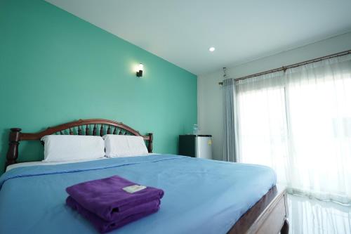 亚兰班萨拜荣格旅馆的蓝色卧室,配有一张大床,上面装有紫包
