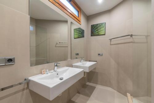 巴塞罗那格拉西亚中心公寓的一间带两个盥洗盆和淋浴的浴室