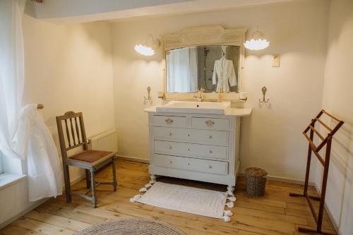 博尔赫隆Huis van Loon的一间带水槽、镜子和椅子的浴室