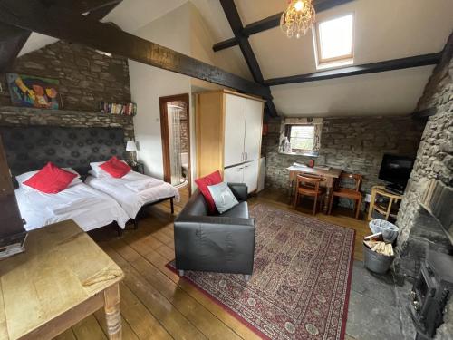 阿伯代尔Tunnel Cottages at Blaen-nant-y-Groes Farm的一间卧室配有一张床、一张沙发和一张桌子