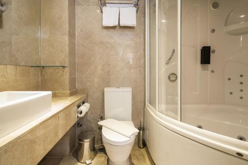 安塔利亚Glamorous Flat with Jacuzzi near Hadrians Gate的浴室配有卫生间、盥洗盆和淋浴。