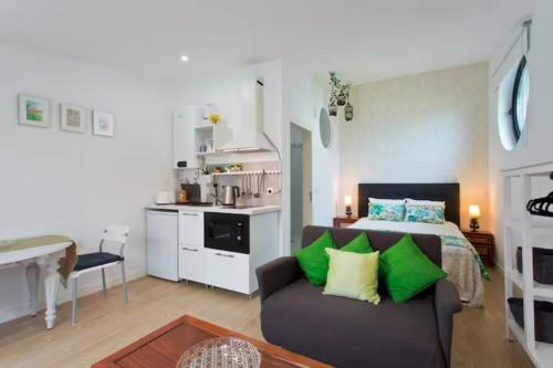 加亚新城Urban Cabin的一间带床和沙发的客厅以及一间厨房。