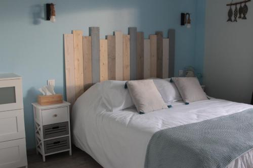 Le Manoir de KEROFIL的卧室内的一张带木制床头板的床