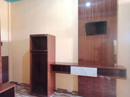 比拉An Nur Homestay Bira Beach的一间设有一张桌子的墙上电视的房间