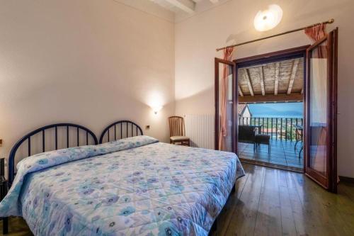 波尔佩纳泽德尔加尔达Casa Vacanze Baccolo的一间卧室设有一张床,并有通往阳台的门