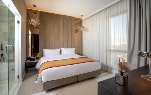 突尼斯Hotel Royal ASBU Tunis的一间卧室配有一张大床和一张书桌