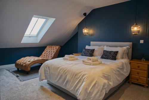 安纳隆Irish Sea Cottage的一间卧室配有一张带椅子的床和一扇窗户