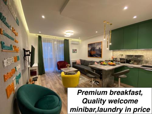 布达佩斯BudapestStyle Superior Family Apartman, Private Parking, Breakfast的厨房以及带绿色橱柜和绿色椅子的客厅。