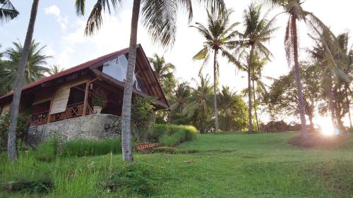PawenangVilla Pintu Bintang的一座棕榈树环绕的度假建筑
