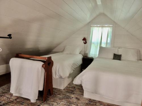 林肯维尔Lakefront Cottage by Country House Escapes的一间卧室设有两张床和窗户。