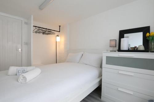 伦敦Anchor Guest House的白色卧室配有白色的床和梳妆台