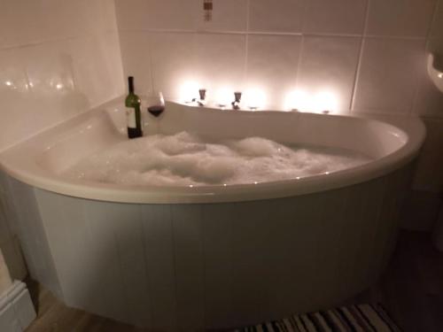 卡姆尔福德Poppy's Place Annex in Camelford North Cornwall的白色浴缸内备有一瓶葡萄酒