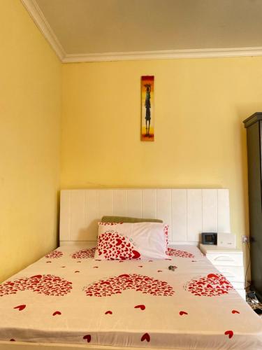 阿鲁沙Cozy studio apartment的一间卧室,床上有红色的鲜花