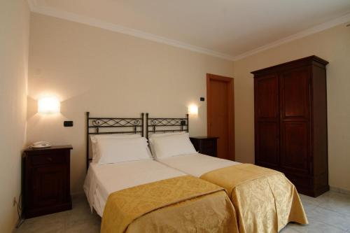 圣乔瓦尼·罗通多Hotel Villa San Pietro的一间卧室配有一张大床和一个木制橱柜