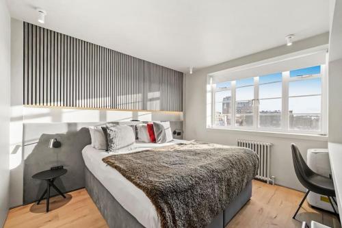 伦敦Two Bedroom Flat in Kensington的一间卧室设有一张大床和一个大窗户