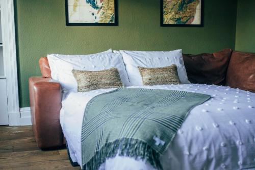 Saint BoswellsThe Main Street Burrow - Your Perfect Hideaway的一张带白色床单和沙发枕头的床