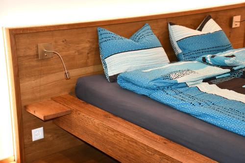 瓦森Hof-Fankhauser的一张带蓝色和白色枕头的床