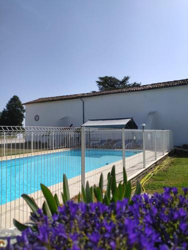 热莫扎克Domaine Moulin d'Elemiah的紫色花卉游泳池周围的围栏