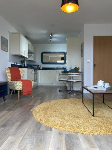 纽基Dog Friendly Stylish Modern Flat, near Beach的厨房以及带桌子和地毯的客厅。