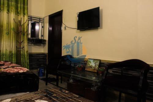 卡拉奇Sk Travellers Inn的客厅配有沙发和墙上的电视