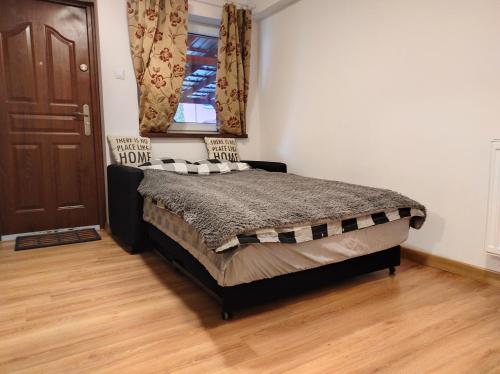 波兹南Flinstones的一间卧室配有一张床,铺有木地板
